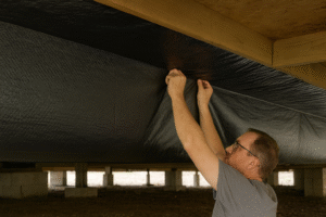 Vapor Barrier being installed under mobile home